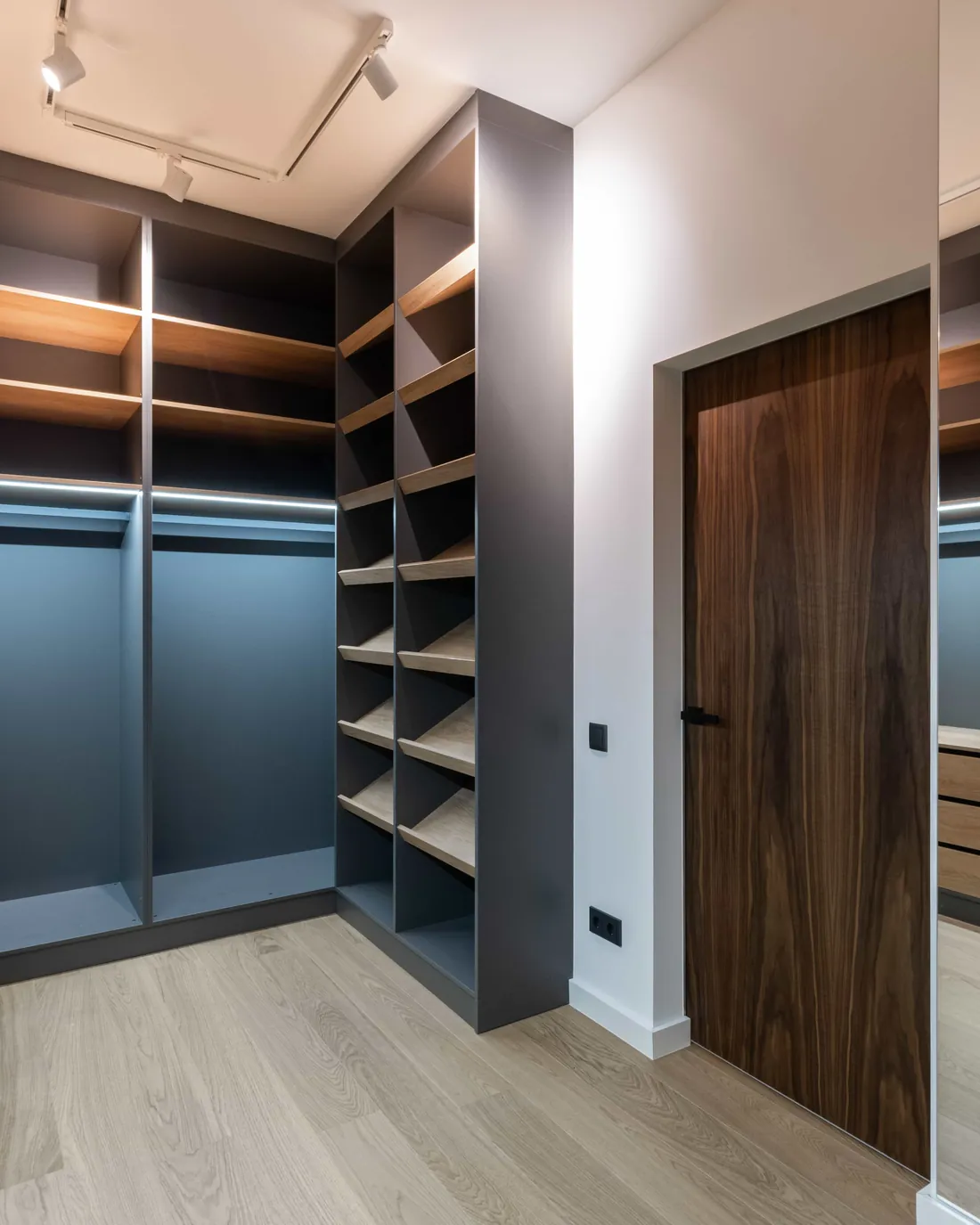 Walk-in closet with lit shelves, drawers and long hanging space