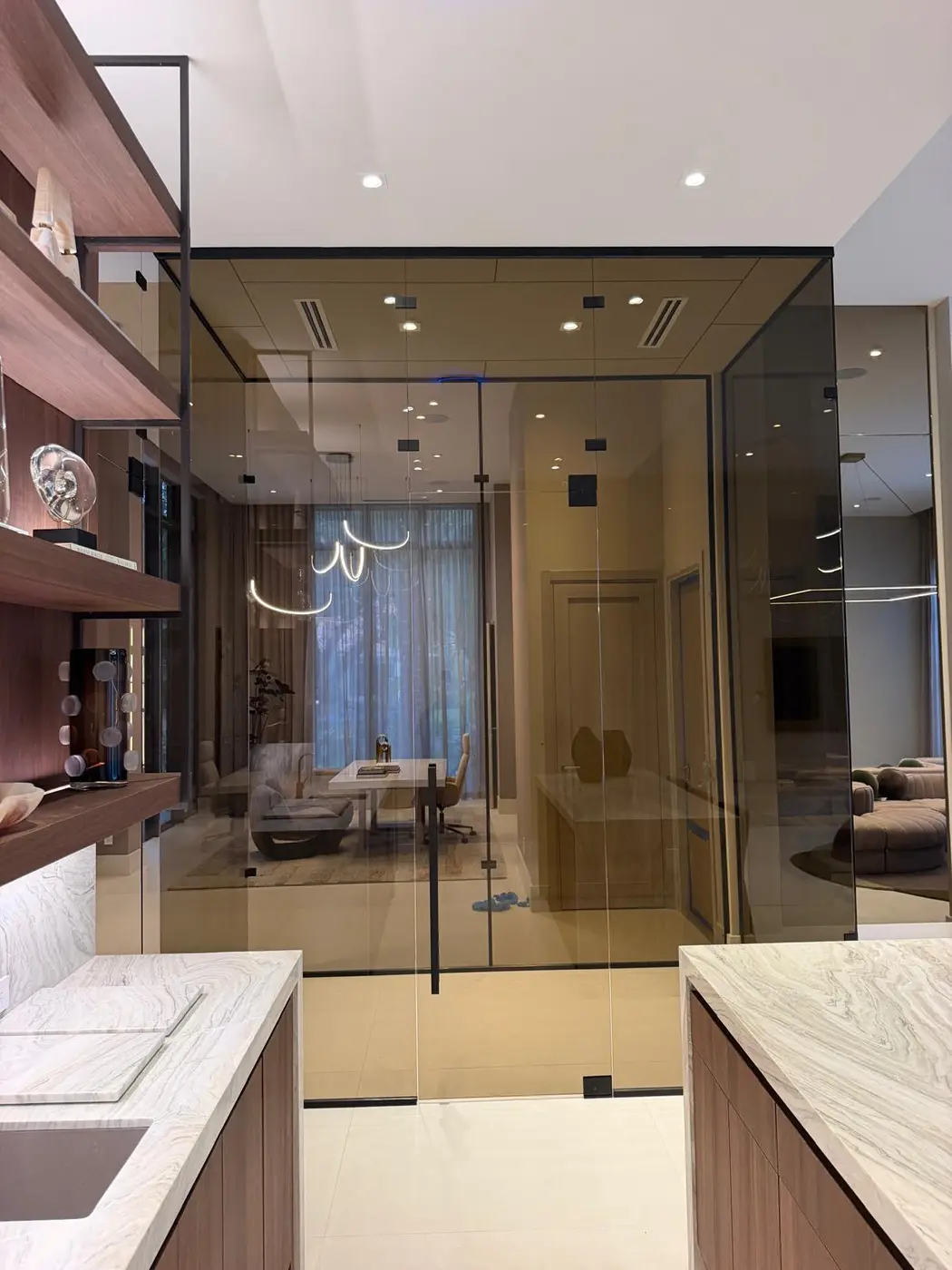 Bronze-tinted glass shower seen past a bathroom vanity