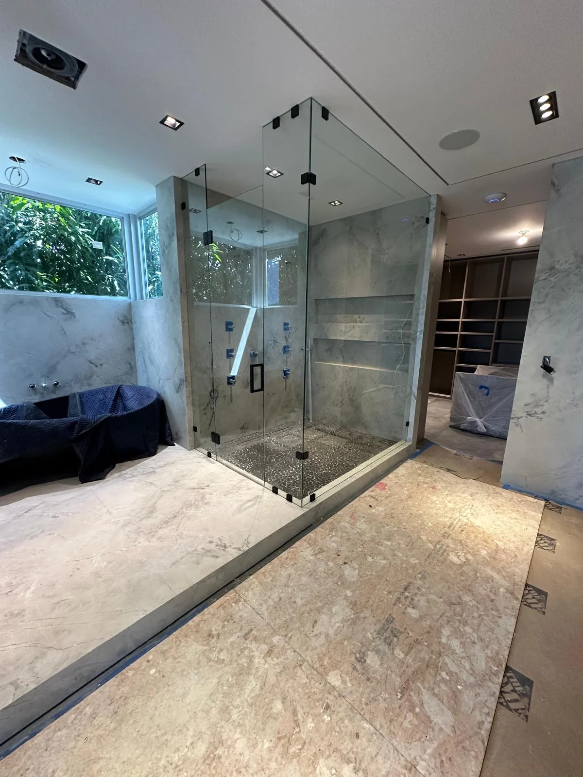 Corner enclosure with tall fixed glass panels and black hardware