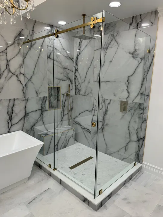 Corner shower with brass sliding hardware and marble walls