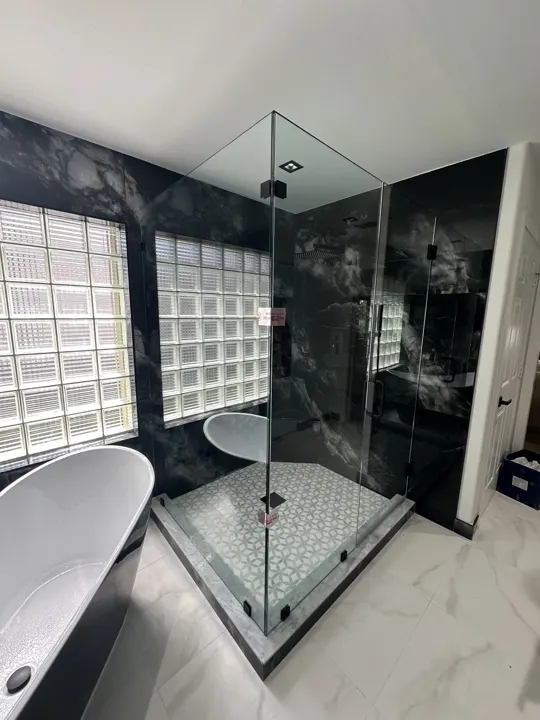 Corner shower with dark marble and glass block window