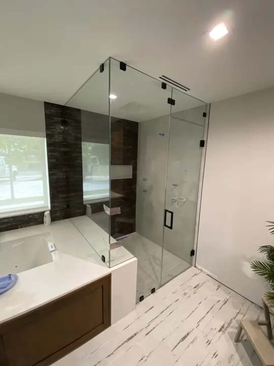 Corner shower with fixed panel beside a built-in tub