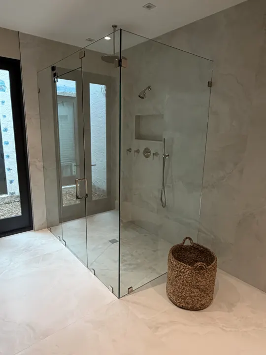 Floor-to-ceiling frameless shower with an inline door