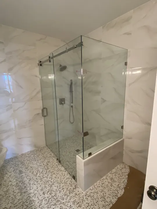 Corner shower with pebble floor and marble walls