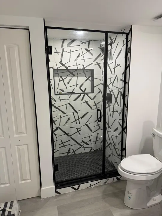 Black-framed shower door with patterned tile