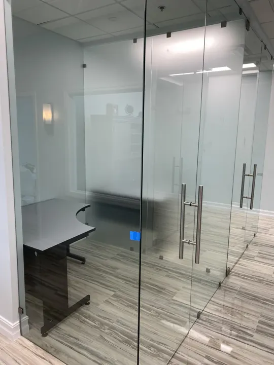 Glass office partitions with frosted bands and a glass door