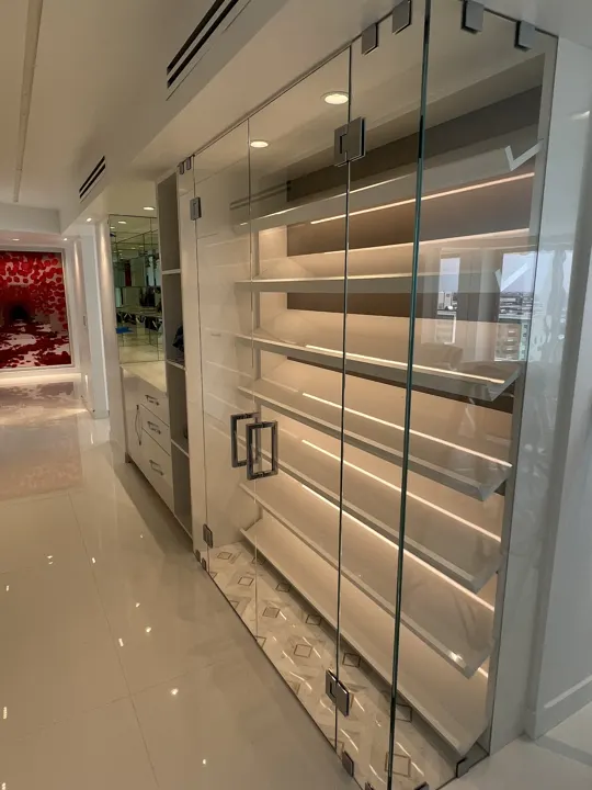Glass wall in front of lit display shelves