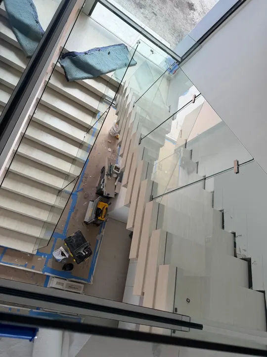 Glass stair railing seen from above during construction